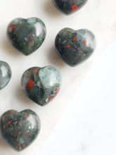 Load image into Gallery viewer, African Bloodstone, rich in spiritual energy, aids physical healing and strength. Its earthy hue, speckled with red, symbolizes vitality, courage, and purpose. This sacred stone enhances intuition, fosters spiritual growth, and boosts physical resilience
