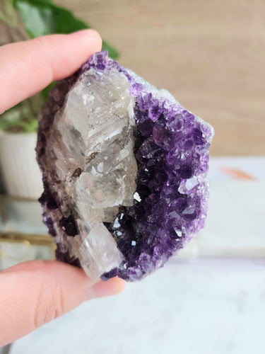 Immerse yourself in the captivating beauty of this Amethyst cluster intertwined with White Calcite. Radiating serene energies, this exquisite piece promotes harmony and balance, making it a perfect addition to any space