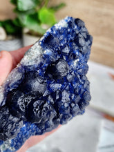 Load image into Gallery viewer, Blueberry Fluorite, with its striking blend of purples and blues, emerges within quartz veins. Esteemed for its ability to enhance clarity and emotional equilibrium, it&#39;s favored in meditation circles for its cleansing and intuition-boosting effects
