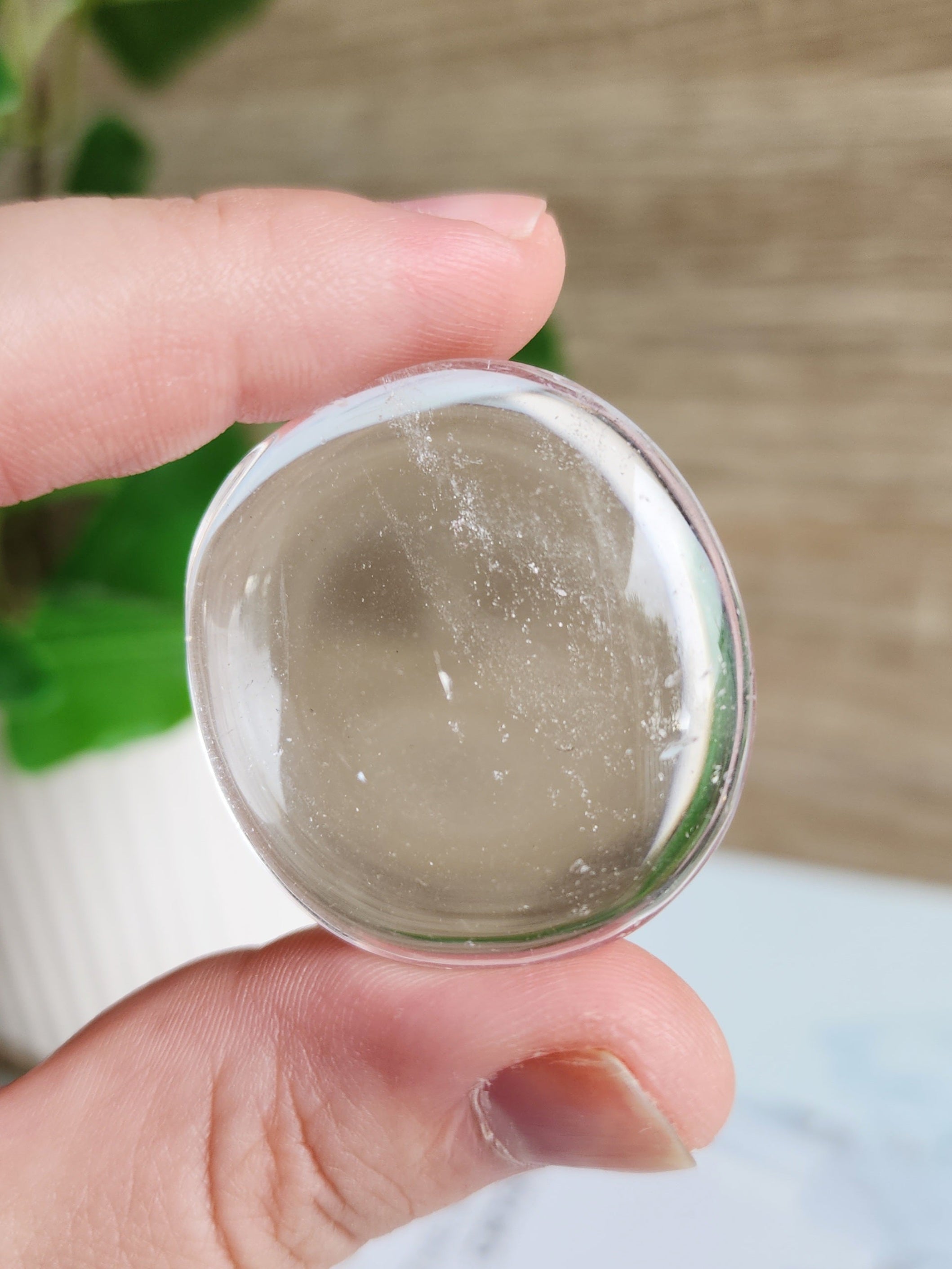 Polished Clear Quartz palm stone featuring transparent to translucent natural quartz with a smooth finish.