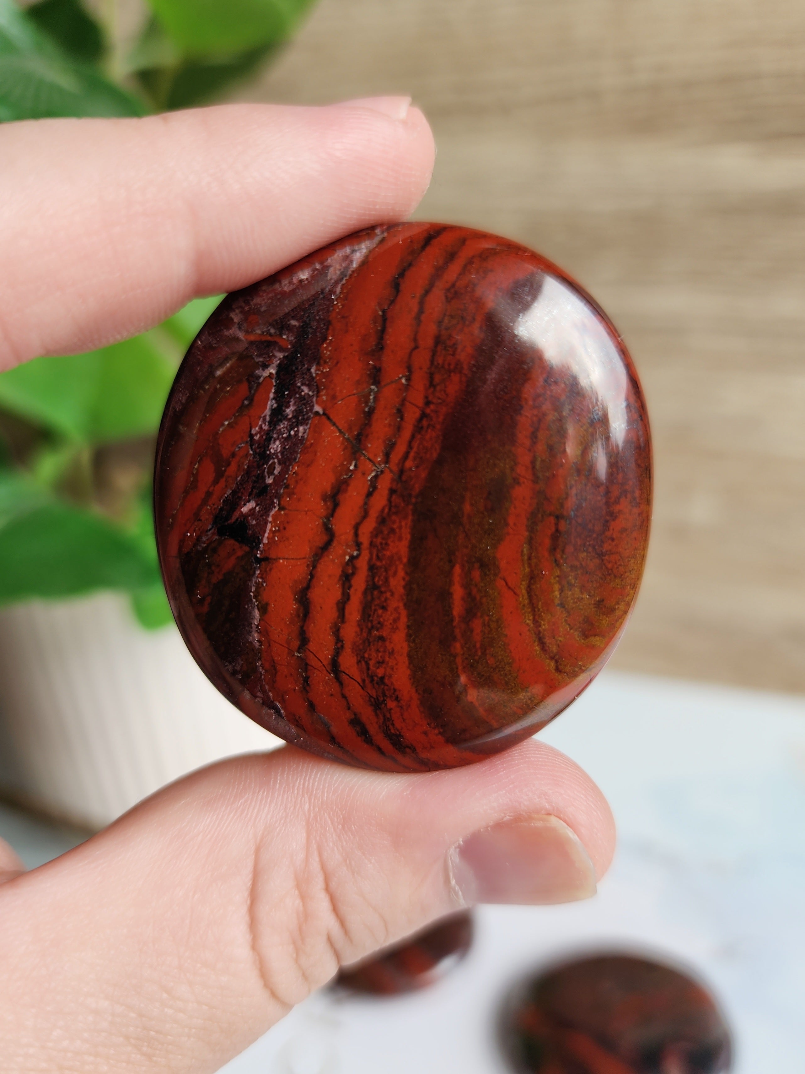Polished Jasper Iron palm stone displaying natural red Jasper and metallic grey Hematite banding.