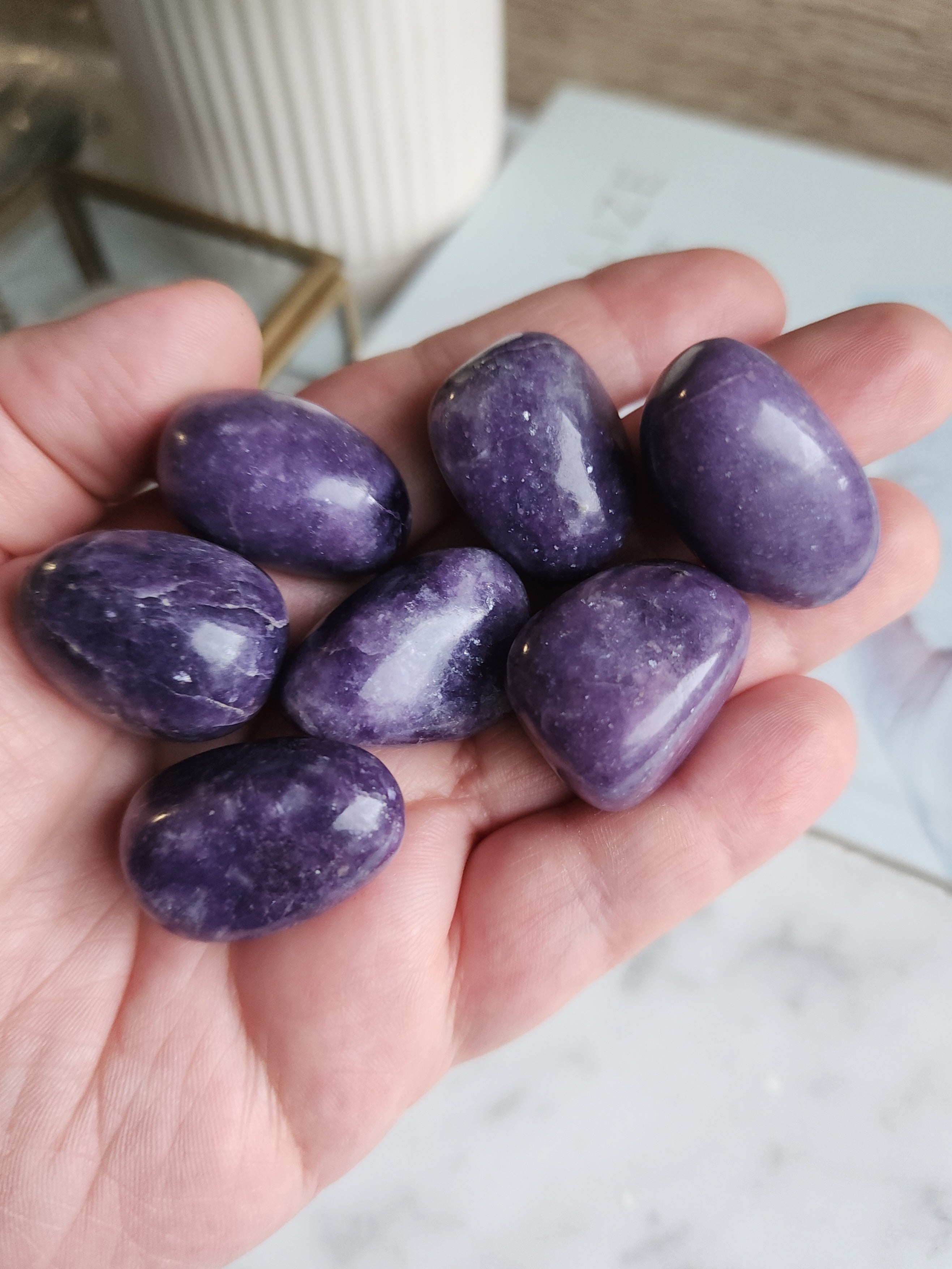 Polished Lepidolite tumble stone displaying natural lilac and purple tones with a soft shimmer.