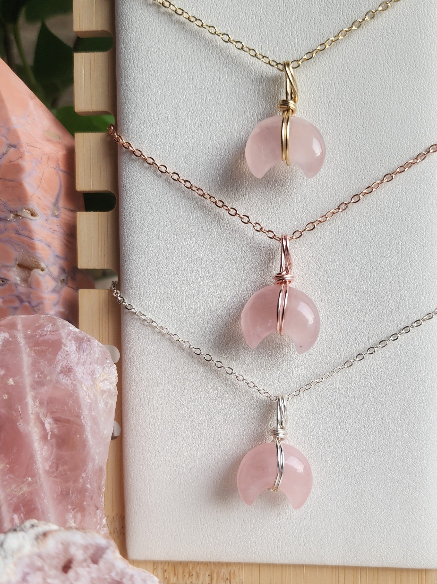 Rose Quartz moon pendant necklace featuring a polished crescent moon carving in soft pink tones, handcrafted in a wire-wrapped design.